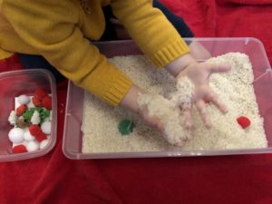 toddler hands close up in rice sensory bin