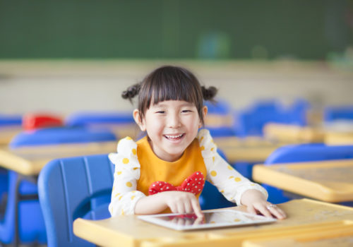 smiling kid using videos for speech therapy